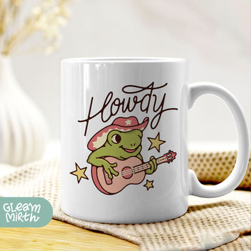 a coffee mug with a frog playing a guitar