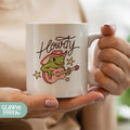 a woman holding a coffee mug with a frog on it