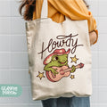 a woman holding a tote bag with a frog on it