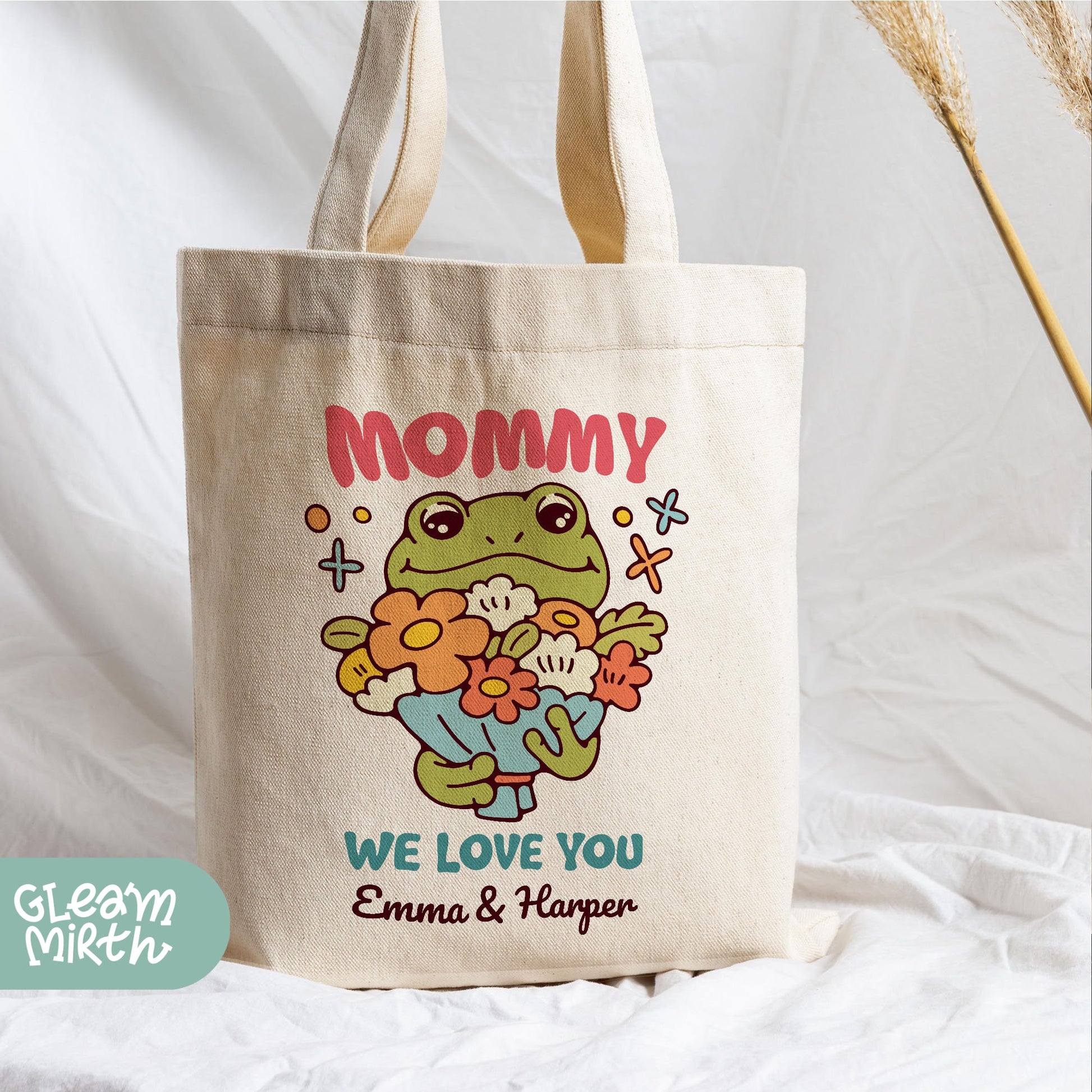 a tote bag with a picture of a frog holding a teddy bear