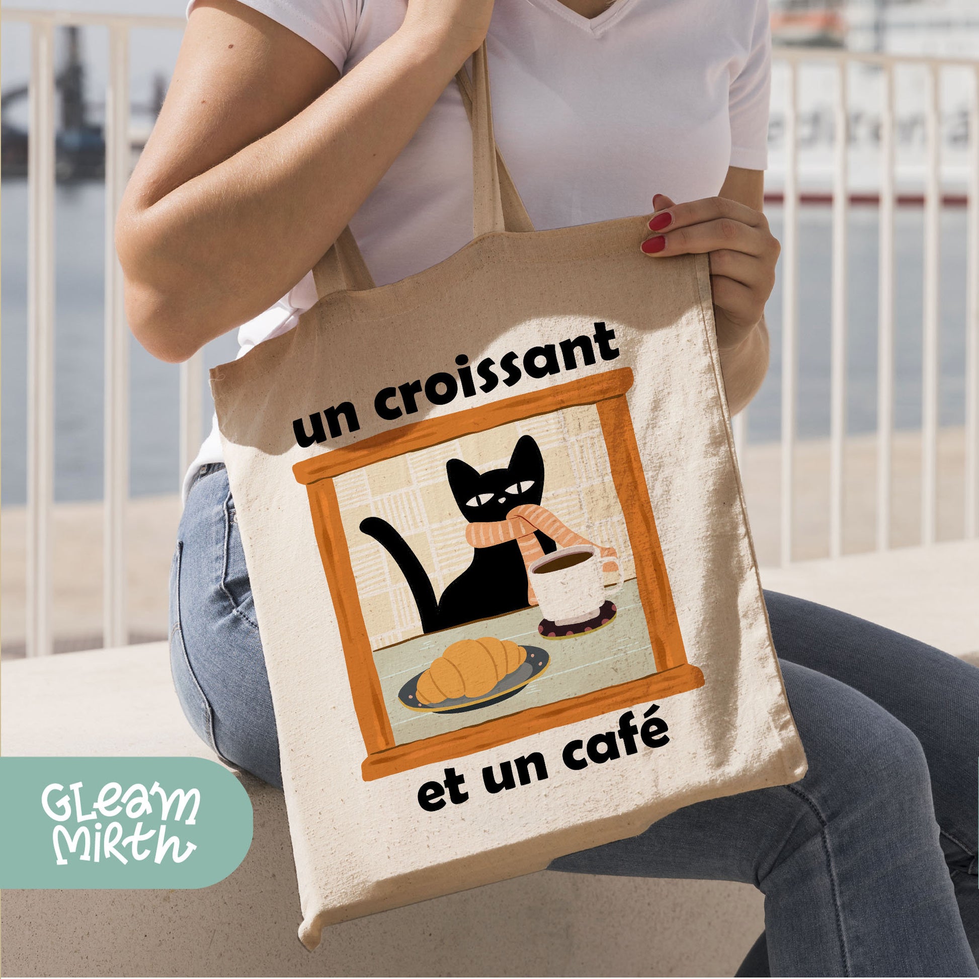 a woman holding a bag with a picture of a cat on it