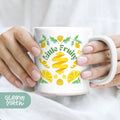 a woman holding a coffee mug with a lemon design on it