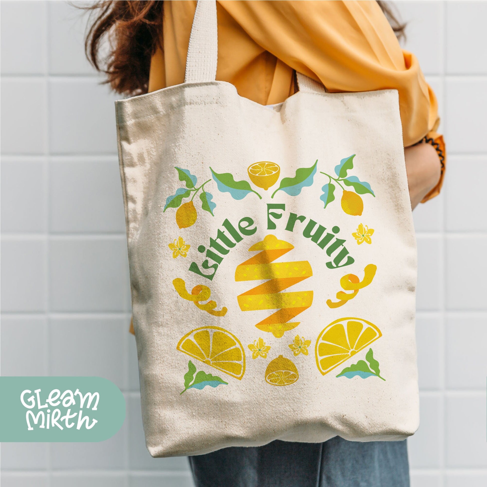 a woman holding a tote bag that says little fruit