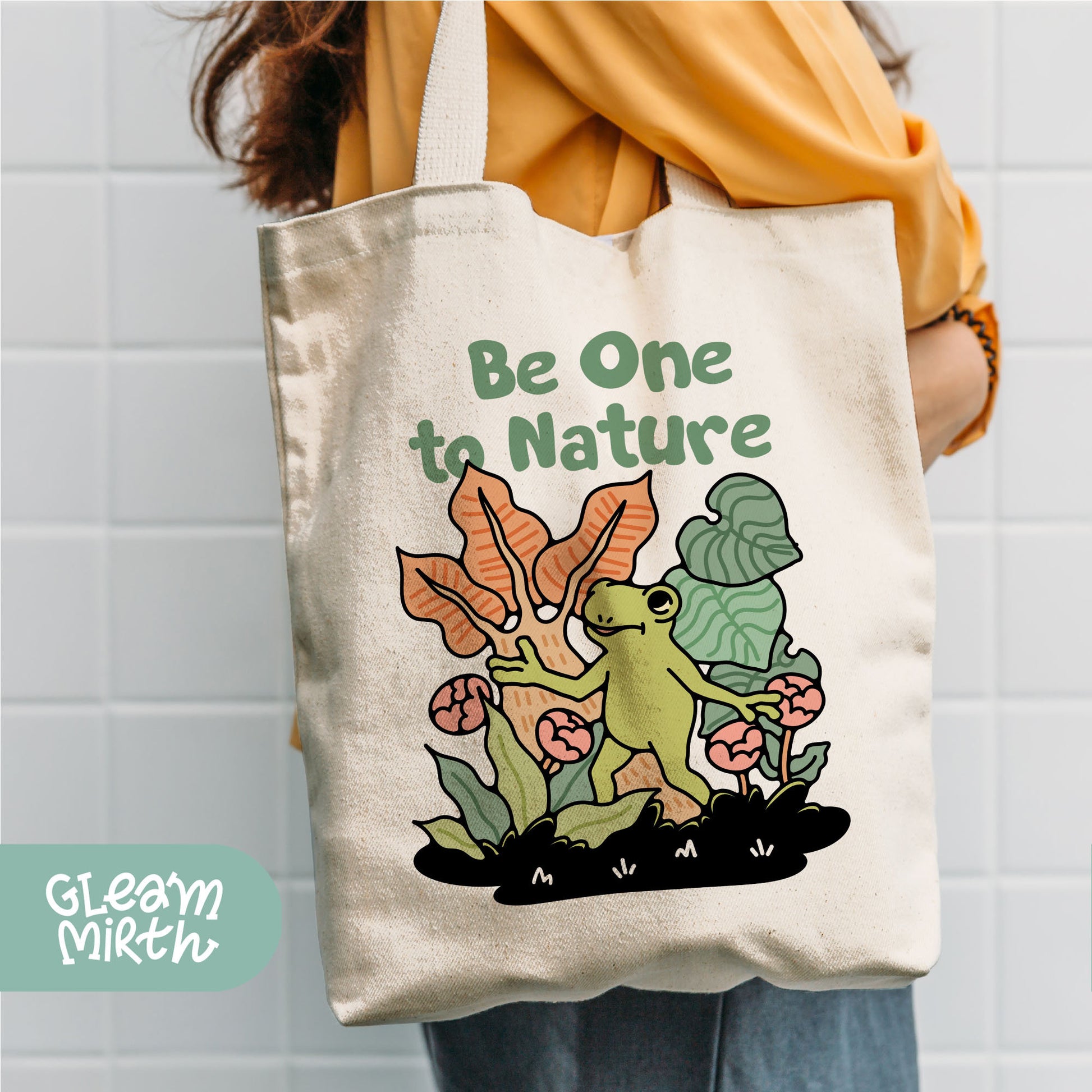 a person holding a tote bag with a picture of a frog