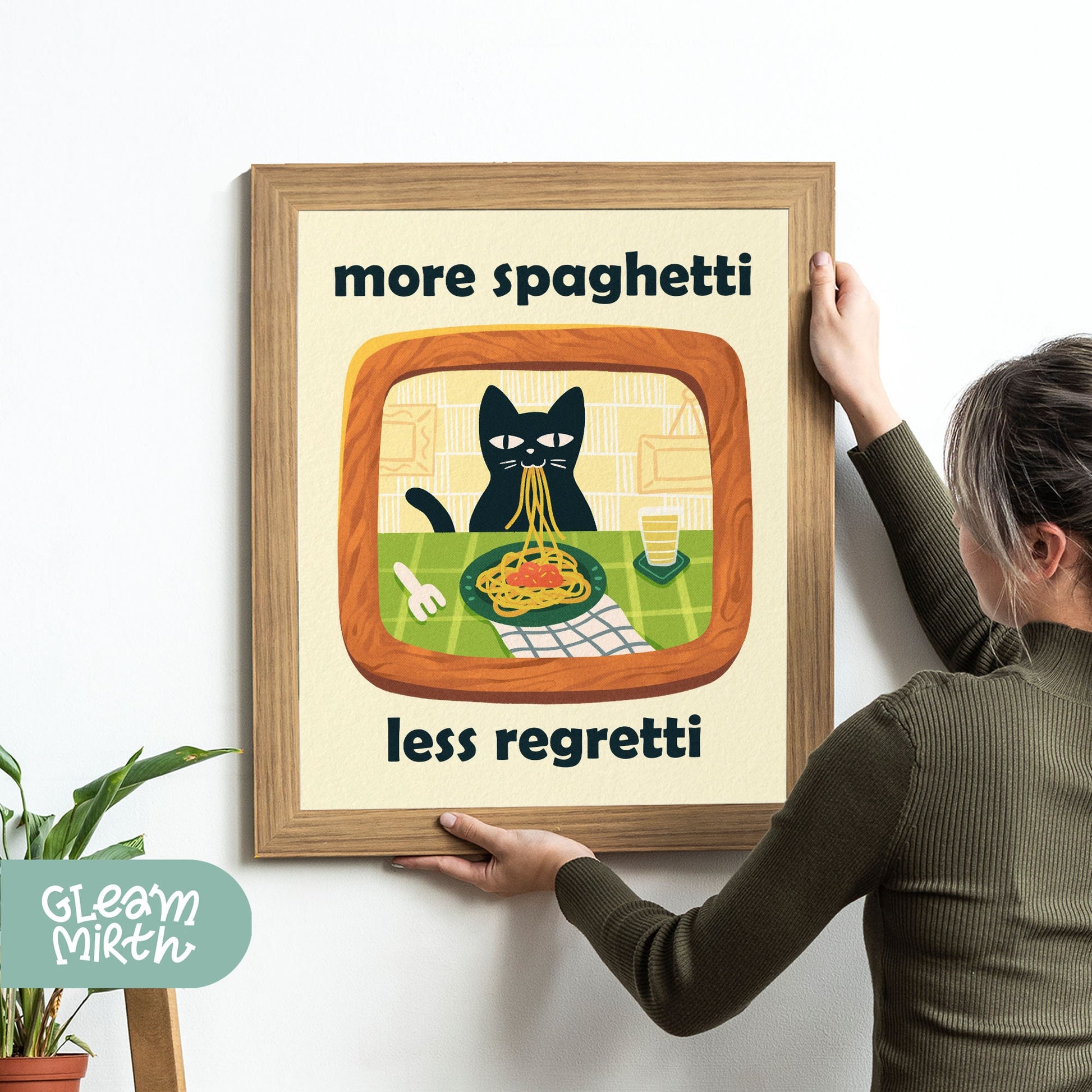 a woman holding up a framed picture of a cat