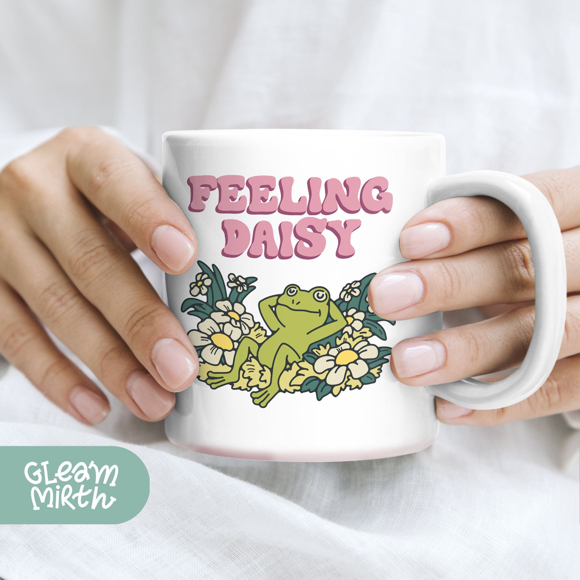 a person holding a coffee mug with a frog on it