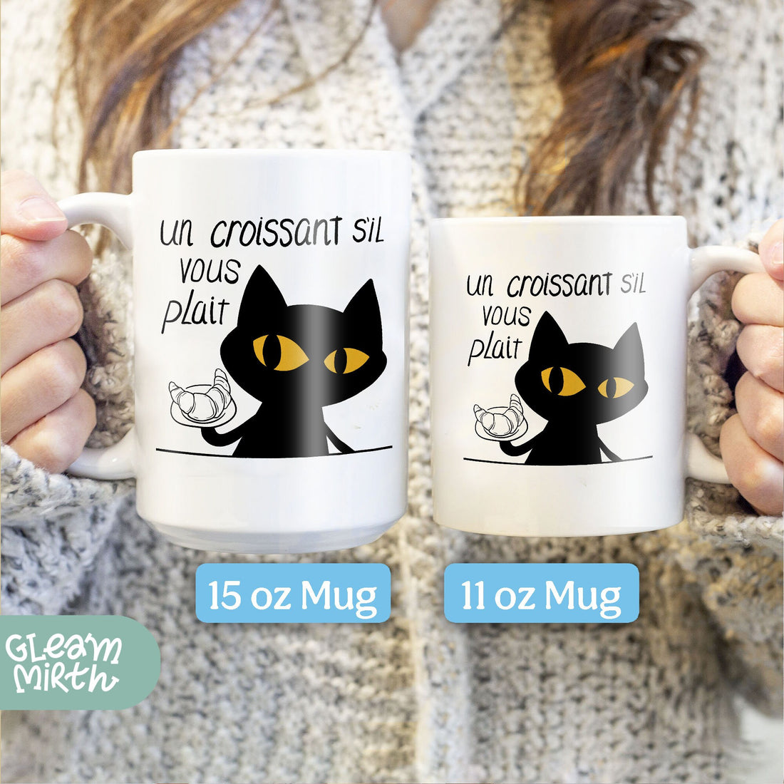 a woman holding a coffee mug with a black cat on it