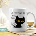 a white coffee mug with a black cat on it