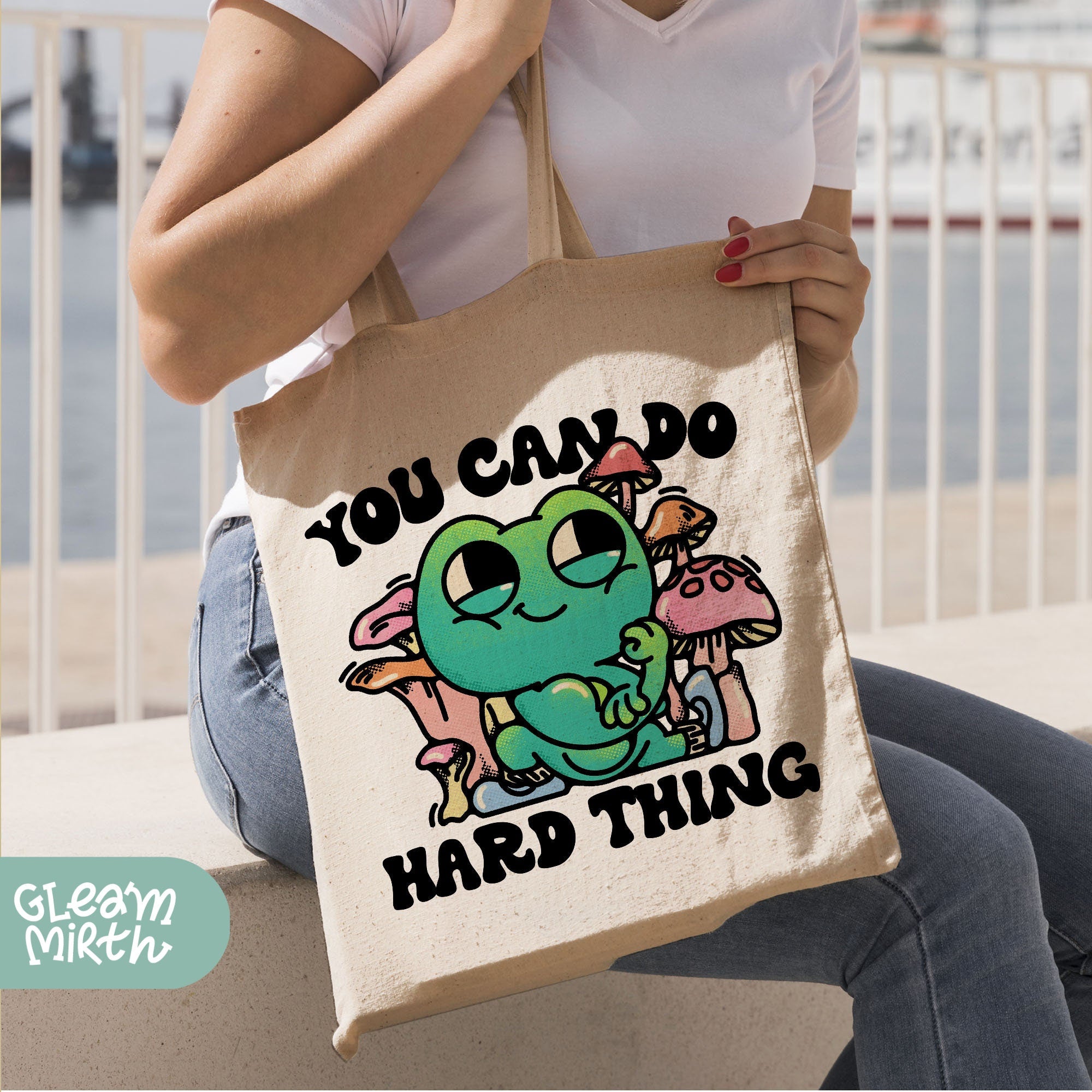 a woman holding a bag that says you can do hard thing