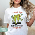 a woman wearing a white t - shirt with an image of a frog holding a