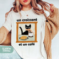 a woman wearing a t - shirt with a picture of a cat and a coffee