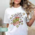 a woman wearing a white t - shirt with a frog playing a guitar