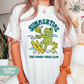 a woman wearing a white t - shirt with a picture of a frog on it