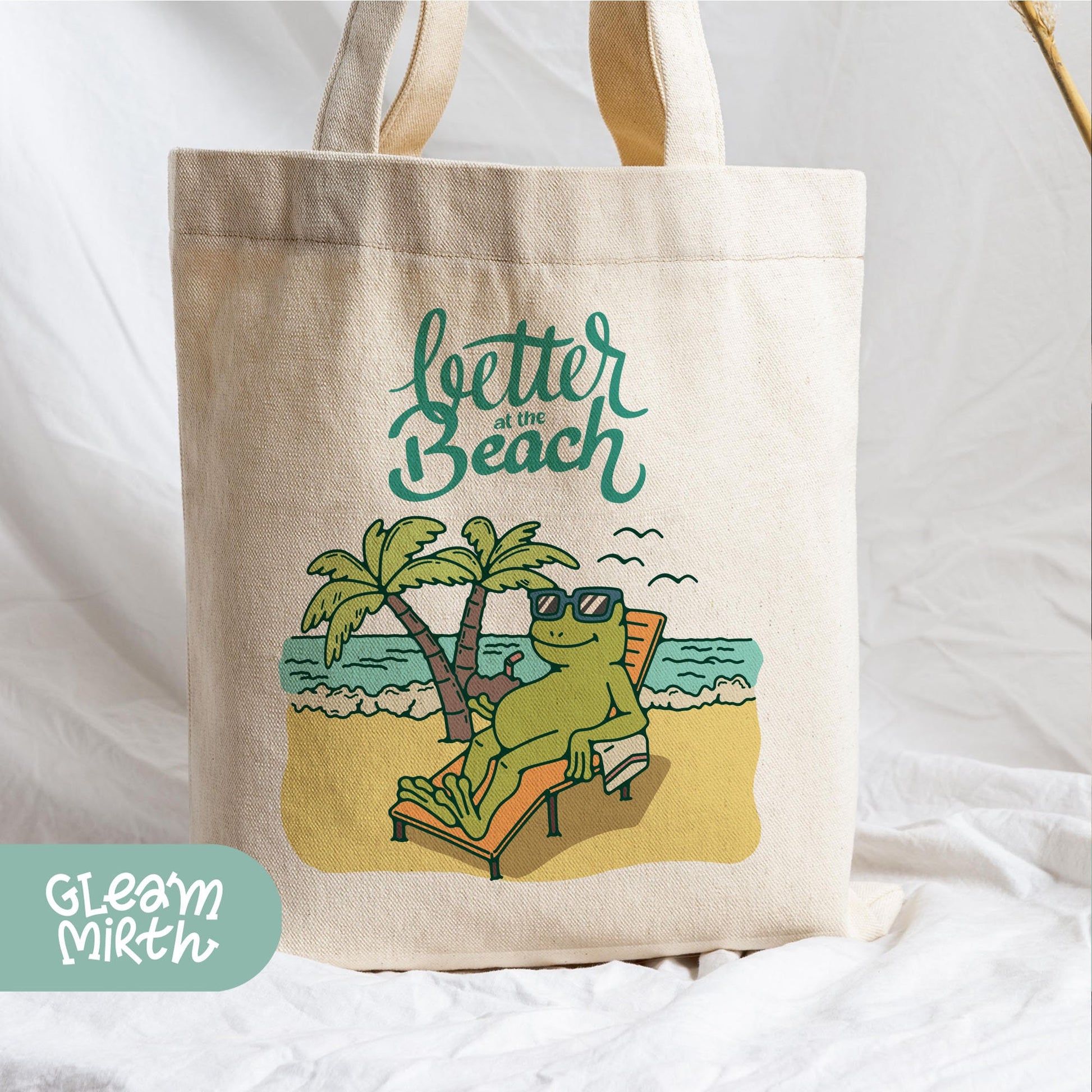 a tote bag with a picture of a frog on the beach