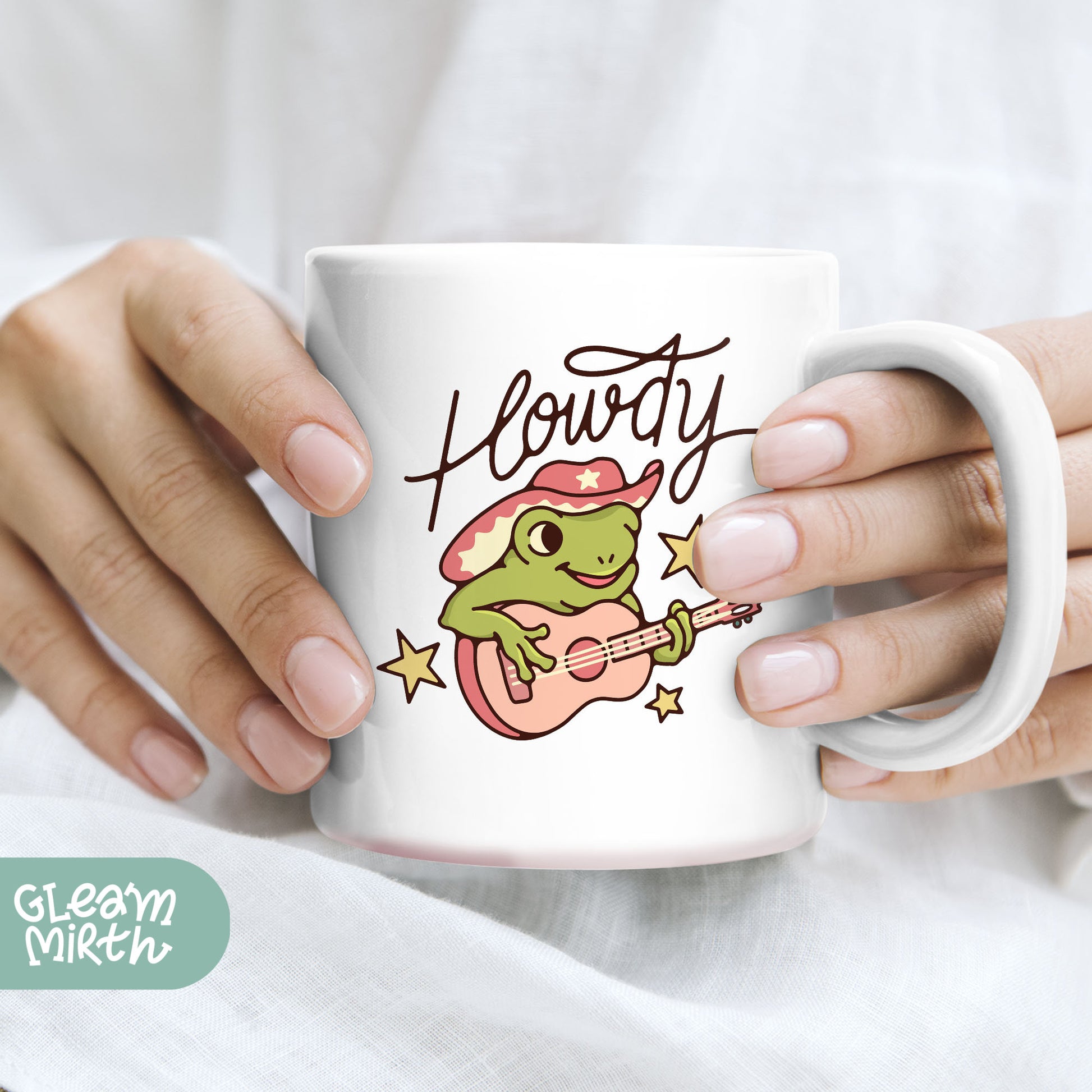 a person holding a coffee mug with a frog on it