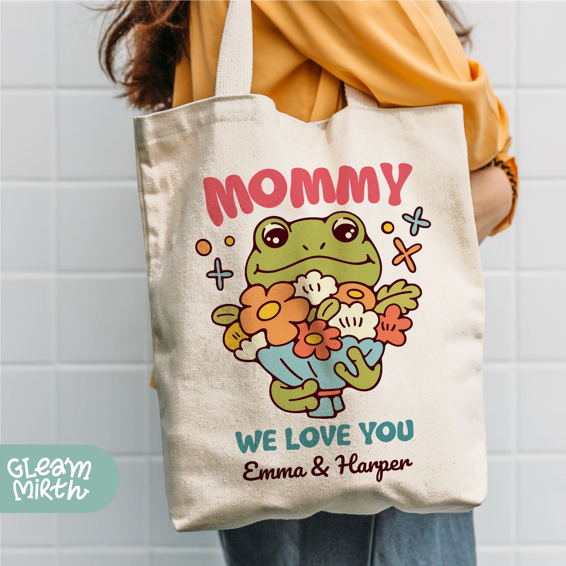 a woman holding a tote bag with a picture of a frog on it