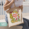 a woman sitting on a bench holding a happy mom's day bag