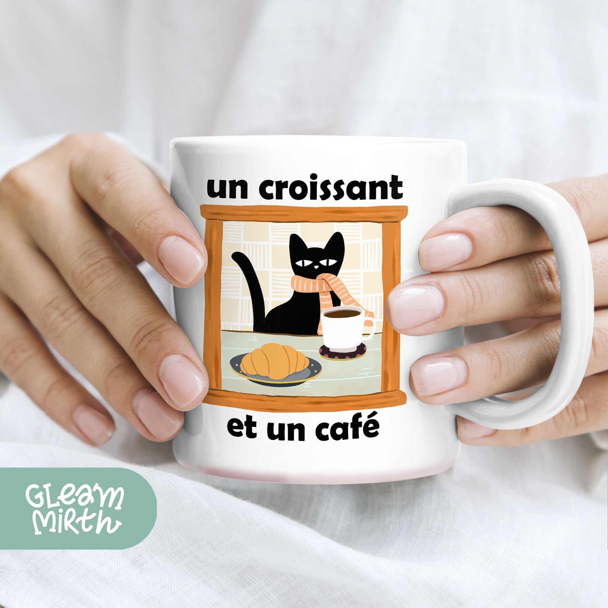 a woman holding a coffee mug with a cat on it