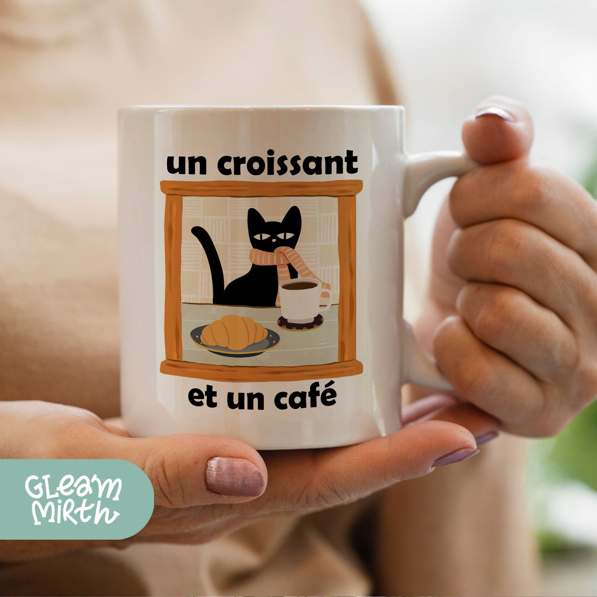 a woman holding a coffee mug with a cat on it