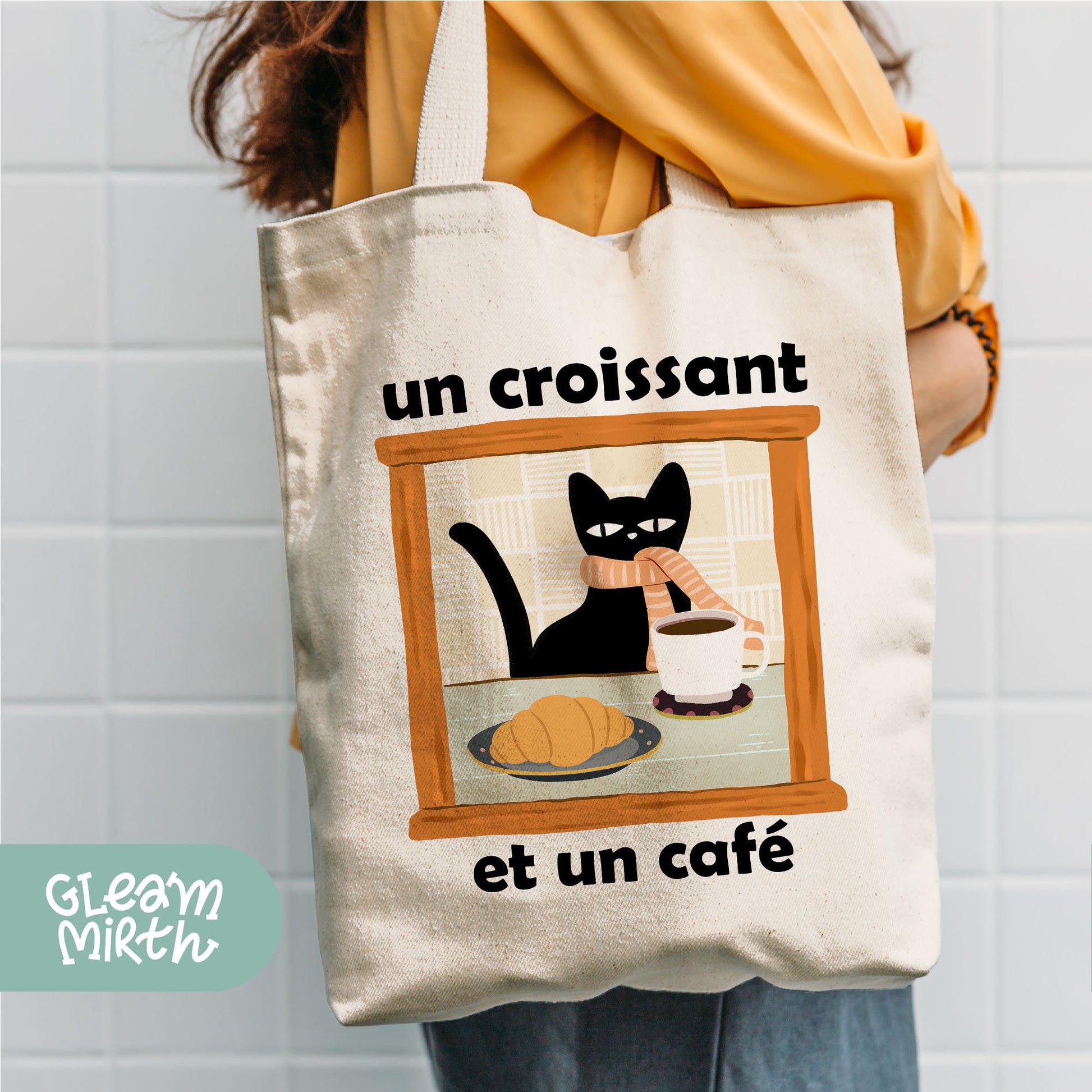 a woman holding a tote bag with a picture of a cat