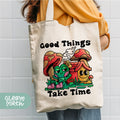 a person holding a tote bag that says good things take time