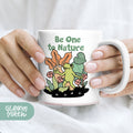 a woman is holding a coffee mug with a picture of a dinosaur on it