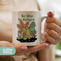 a woman holding a coffee mug with a picture of a frog on it