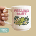 a person holding a coffee mug with a frog on it