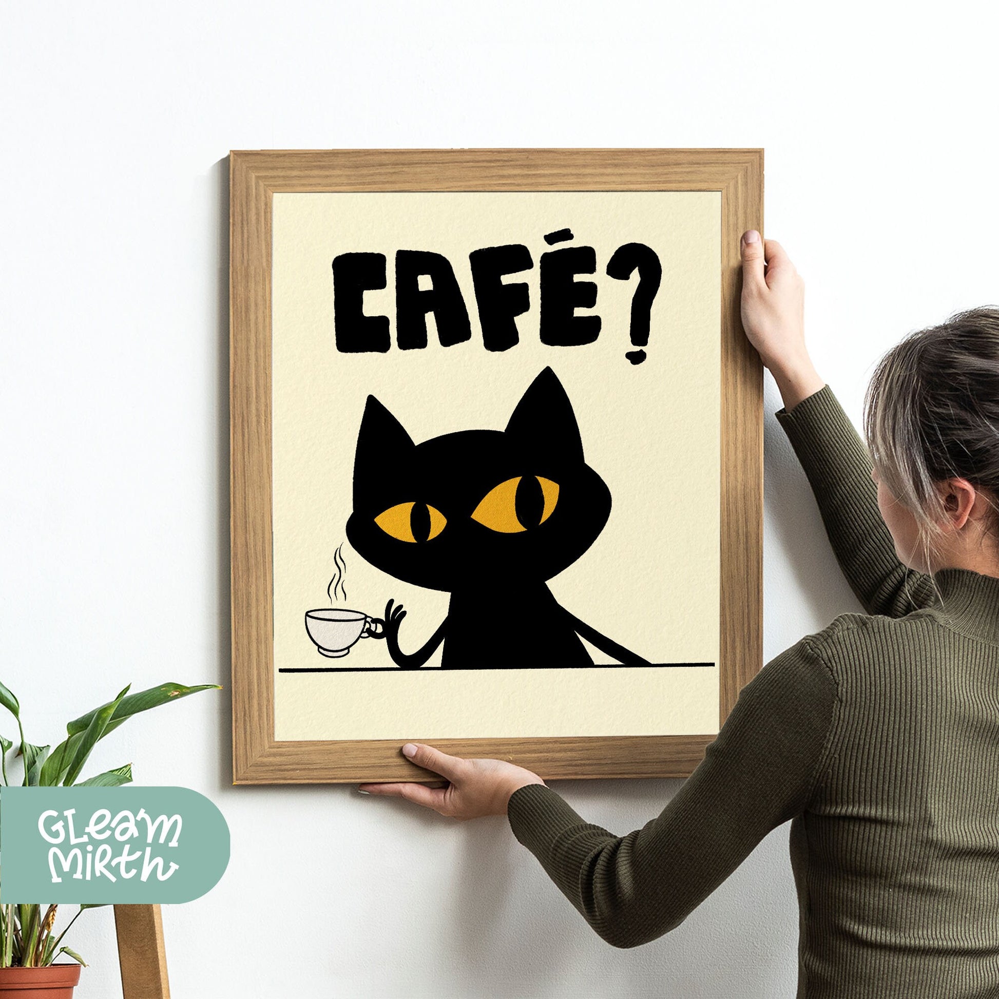 a woman holding a framed picture of a black cat