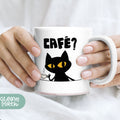 a woman holding a coffee mug with a black cat on it