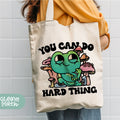 a woman holding a tote bag with an image of a cartoon character