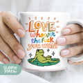 a person holding a coffee mug with a frog on it