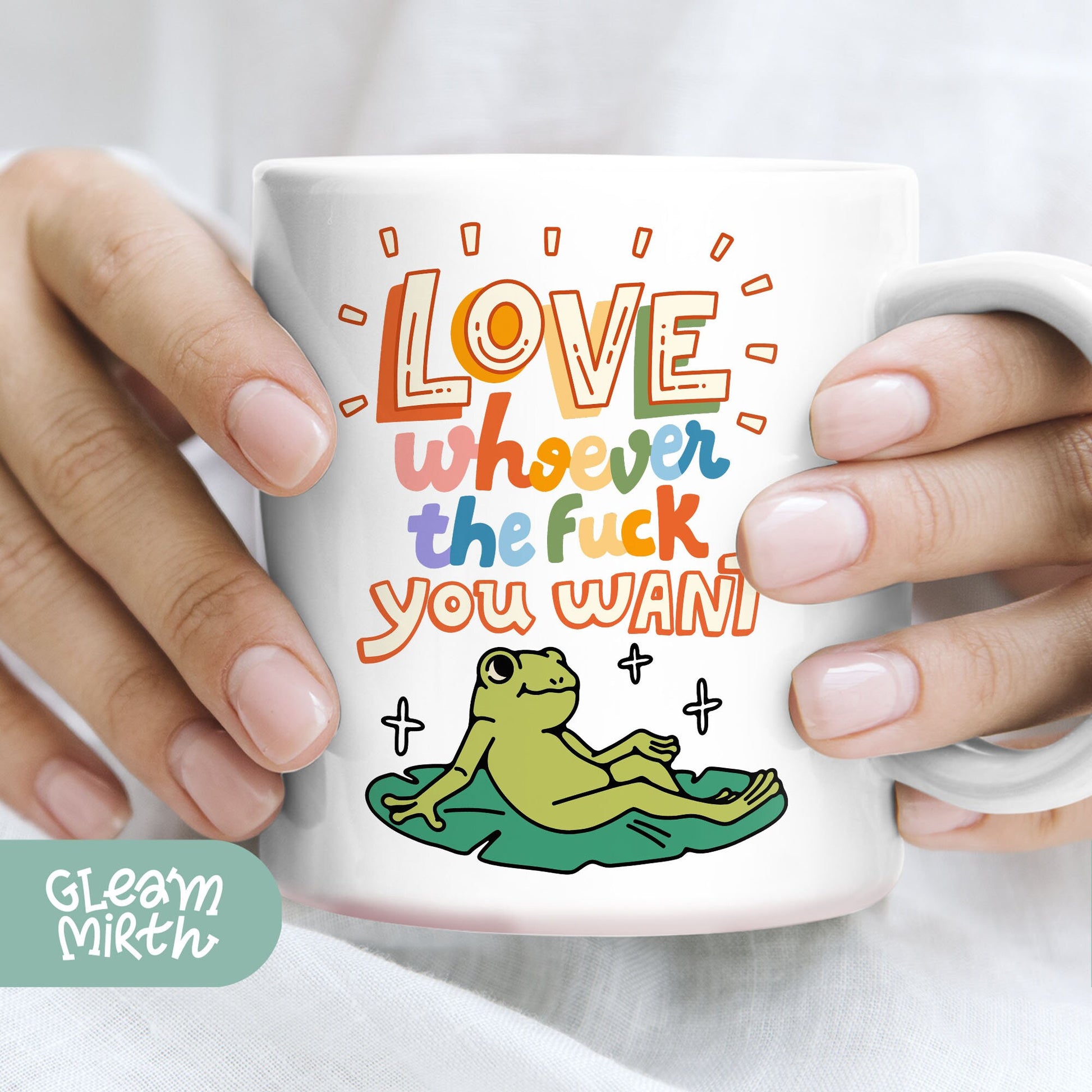 a person holding a coffee mug with a frog on it