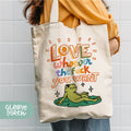 a woman holding a tote bag with a frog on it