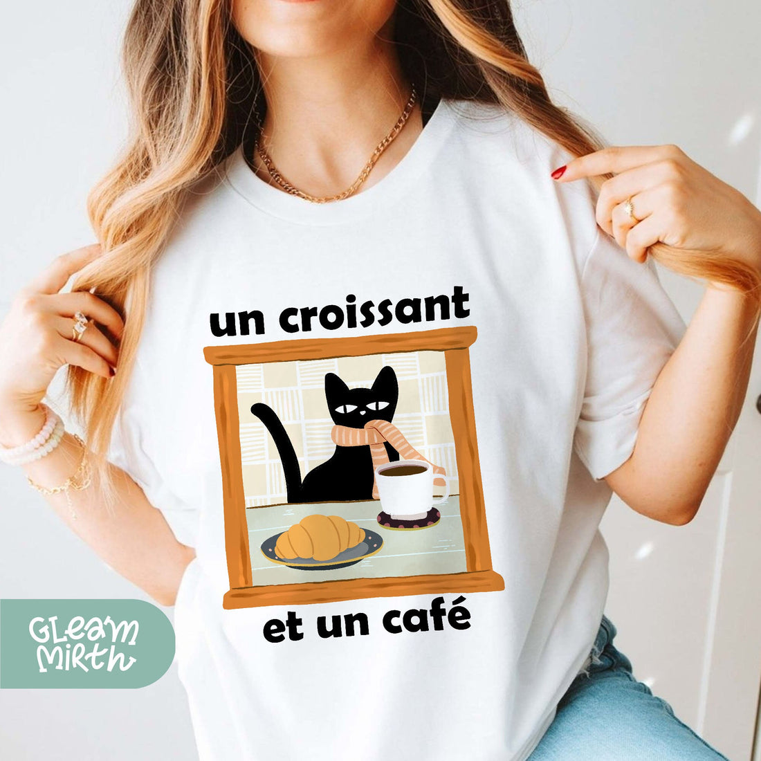 a woman wearing a white shirt with a black cat on it