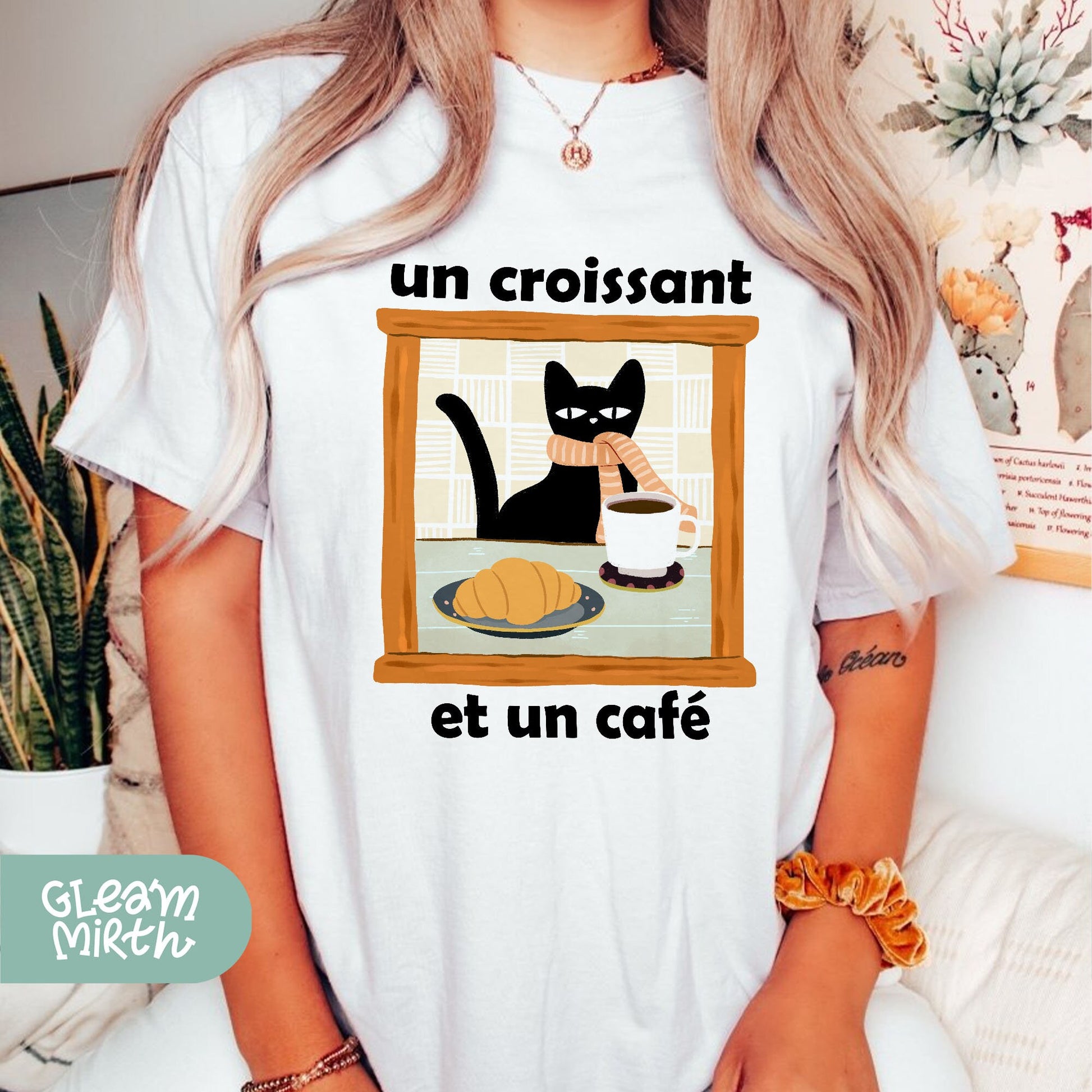 a woman wearing a t - shirt with a picture of a cat and a bowl