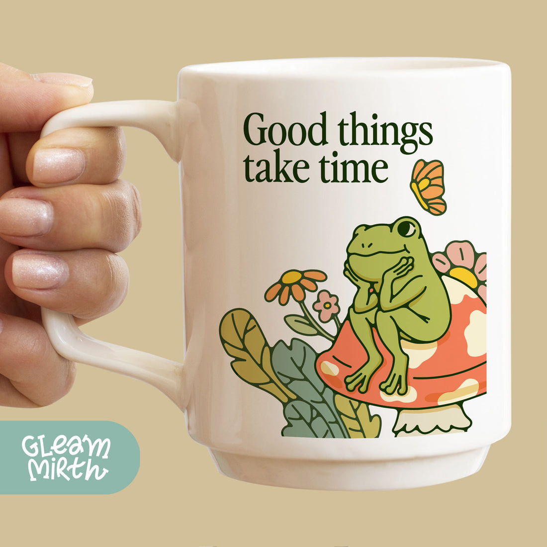 a person holding a coffee mug with a picture of a frog on it