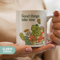 a woman holding a coffee mug with a dinosaur on it